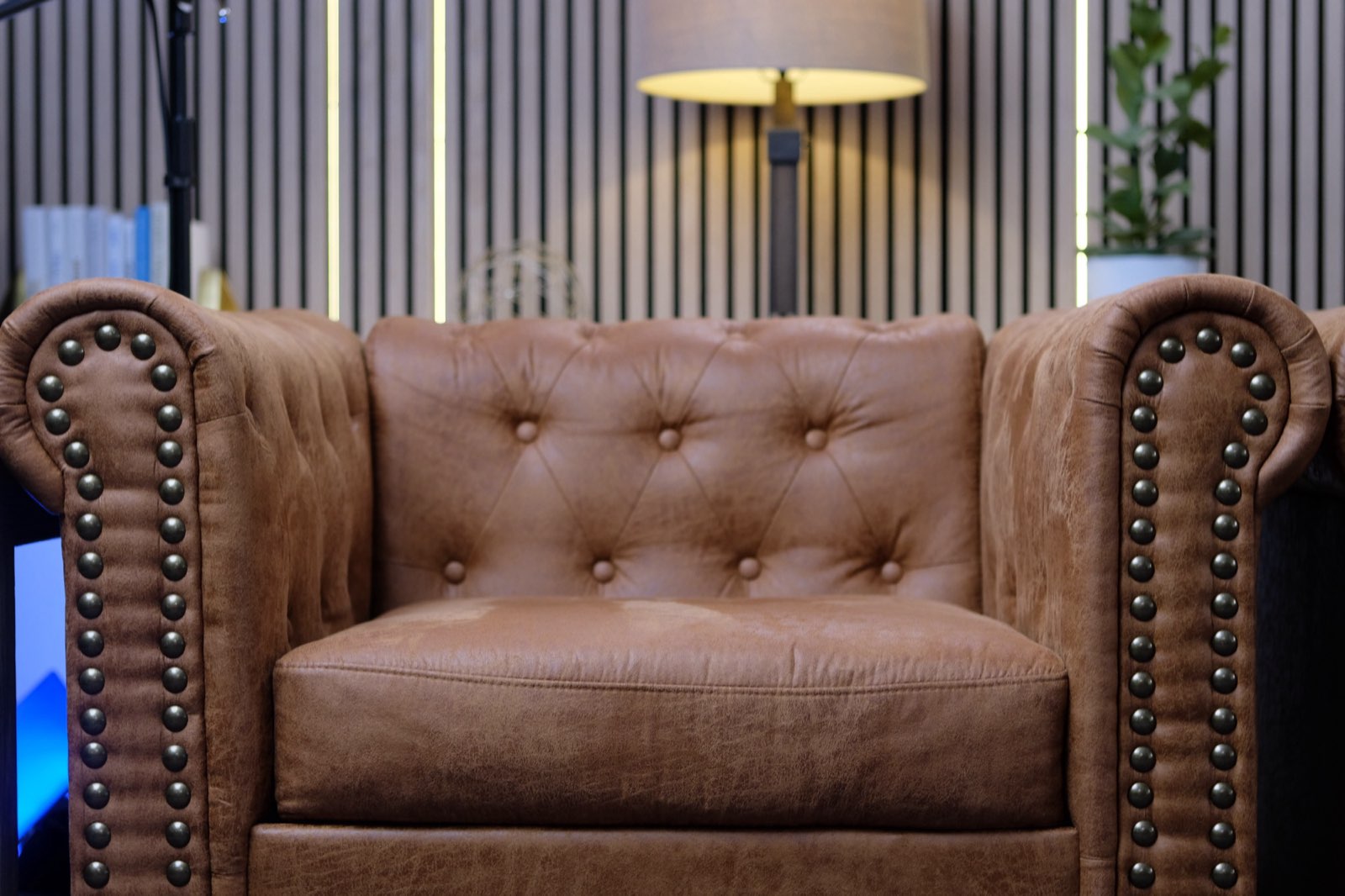 A single chair framed straight to camera against a slatted wood backdrop in a studio built by BYND Media